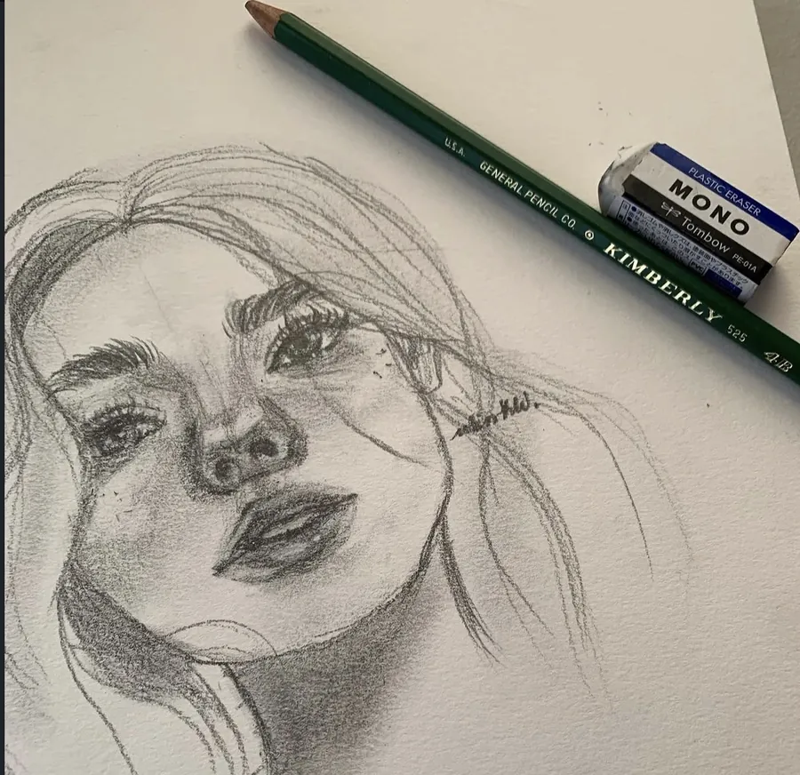 A loose graphite portrait of a woman, with a pencil and eraser beside it.